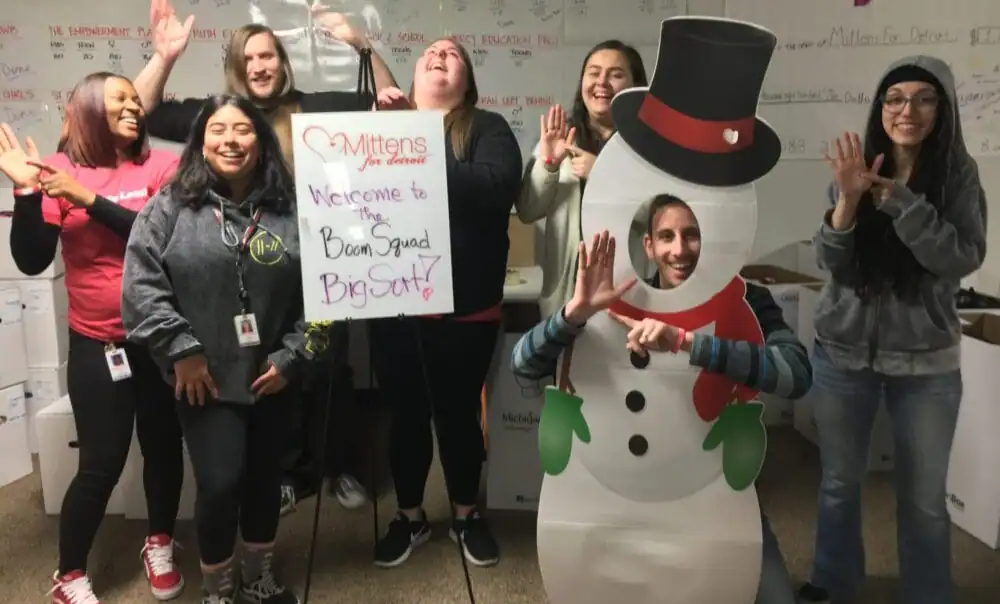 Group of diverse women celebrating with snowman cutout at MFD Staging event.